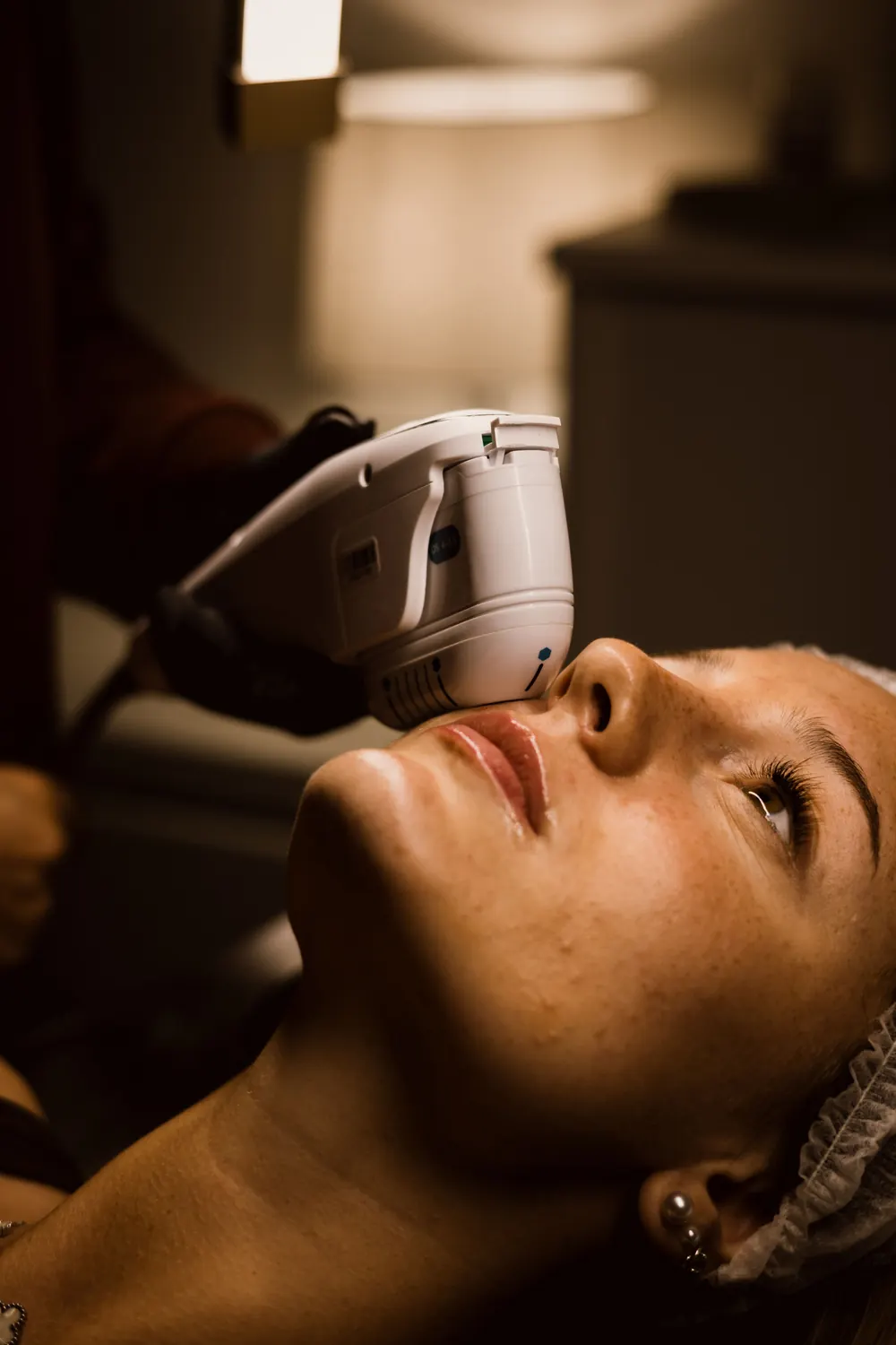 Skin tightening device being used during a non-surgical facial treatment